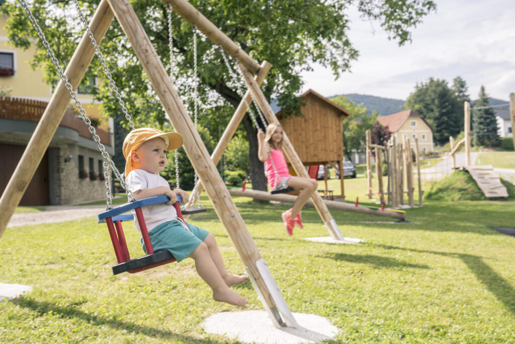 Kinder beim Schaukeln auf einem Spielplatz