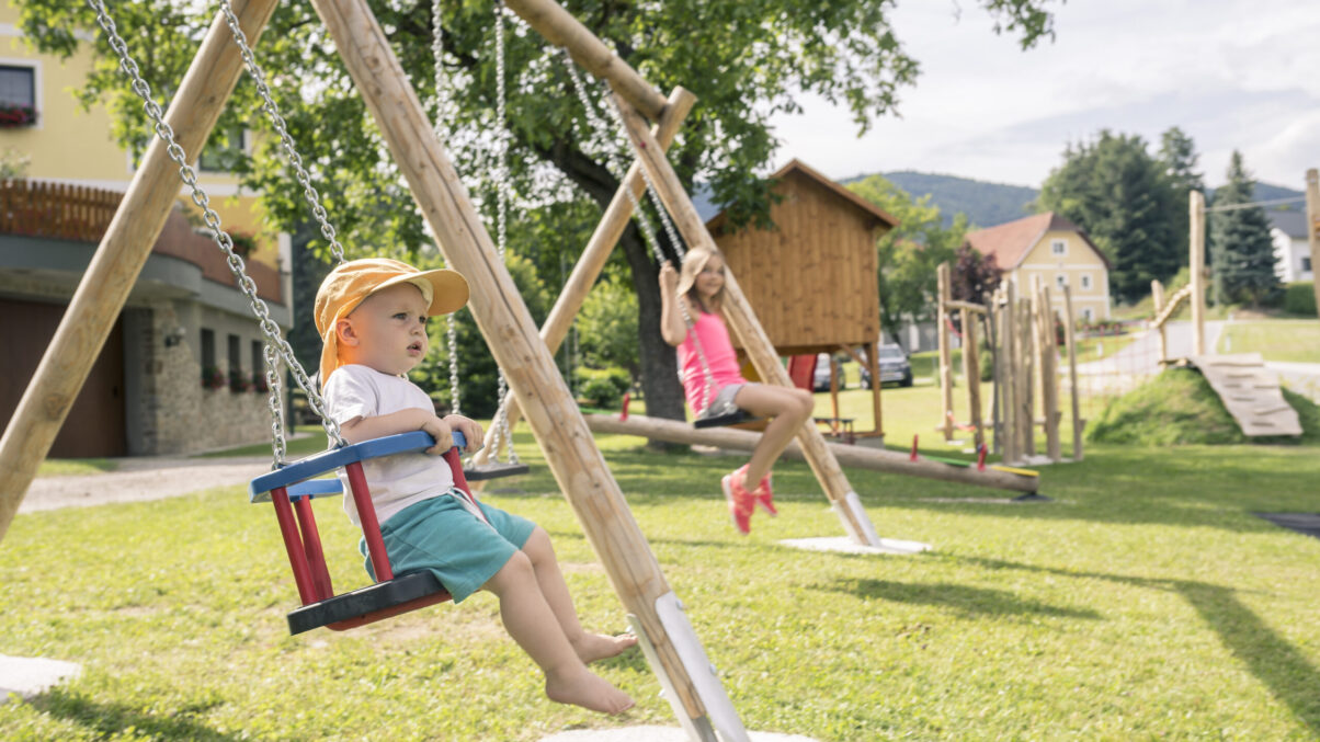 Kinder beim Schaukeln auf einem Spielplatz